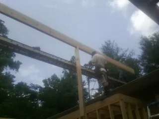 Carpenter setting a ridge beam over a new addition frame — Ice Dam Removal by Roofing Brothers in Laporte