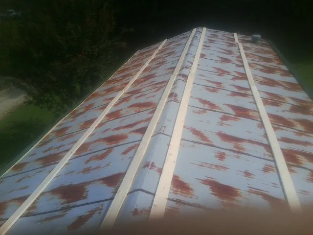Rusted metal roof panels with new wood purlins before replacement — Storm Damage Roof Repair in Laporte by Roofing Brothers