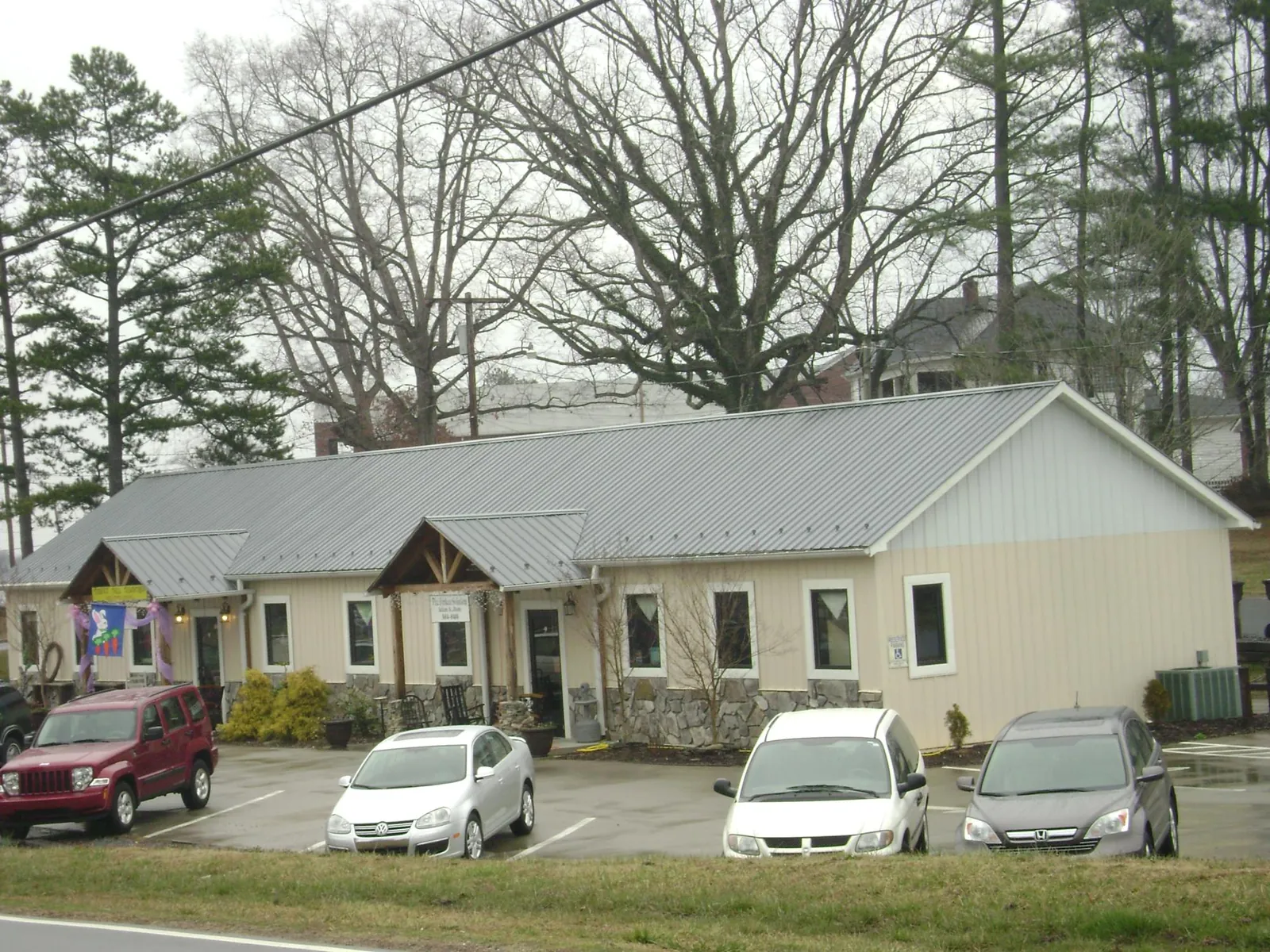 Gray metal roof with timber entry brackets on a small commercial building in Laporte