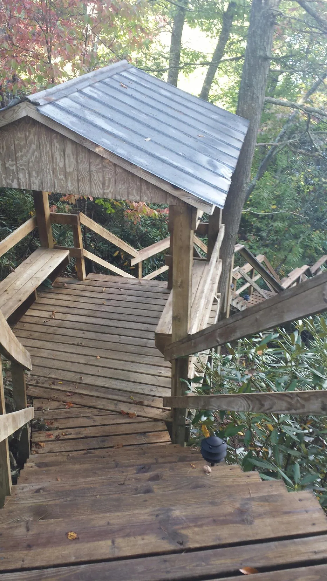 Metal roofed shelter over wooden steps on a wooded walkway — Skylight Repair & Installation work by our crew in Laporte